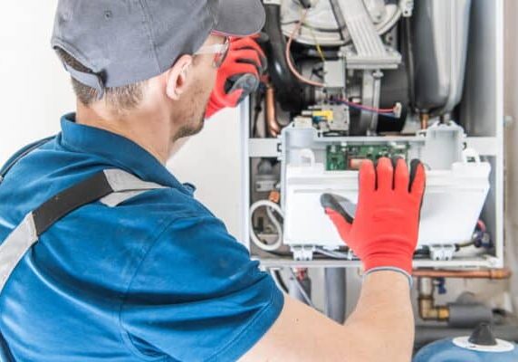 High-efficiency HVAC technician repairing heating system, energy solutions, McDougall Energy services.