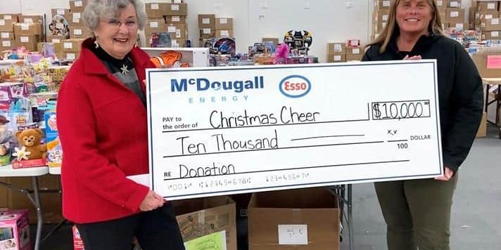 $10,000 donation check for Christmas Cheer by McDougall Energy at charity event.
